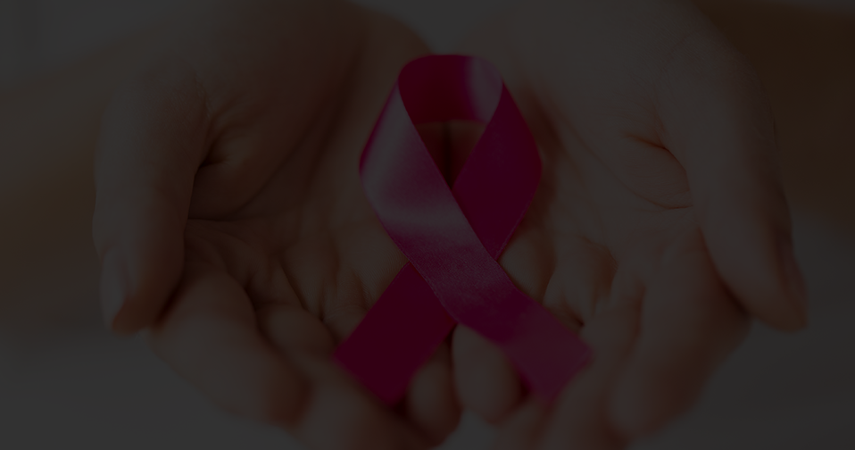 Woman holding pink ribbon for breast cancer in her hands