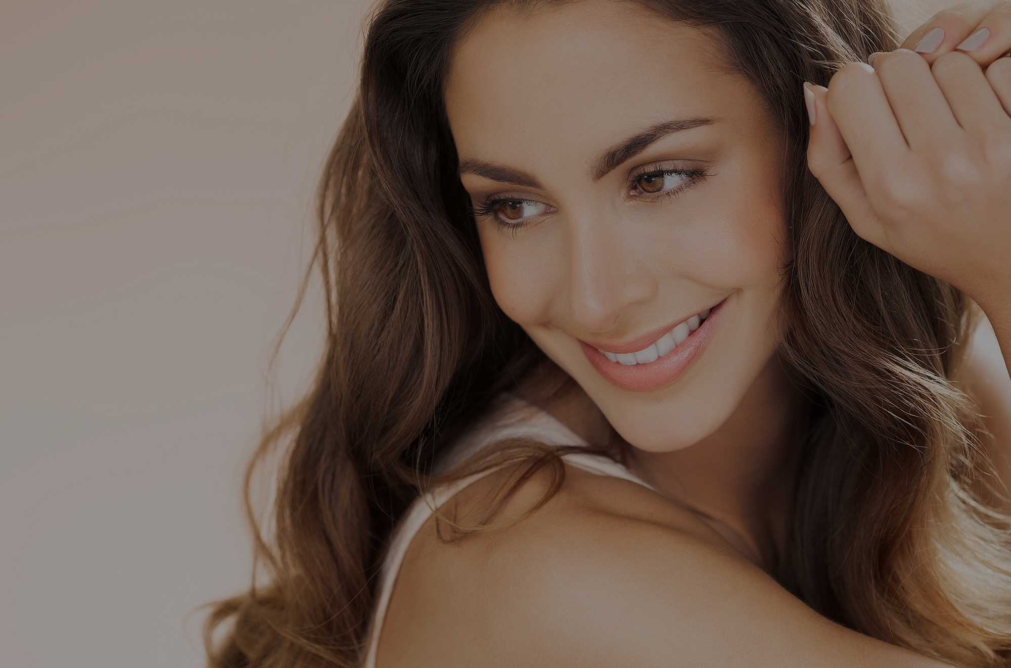 Brunette woman smiling and looking down.