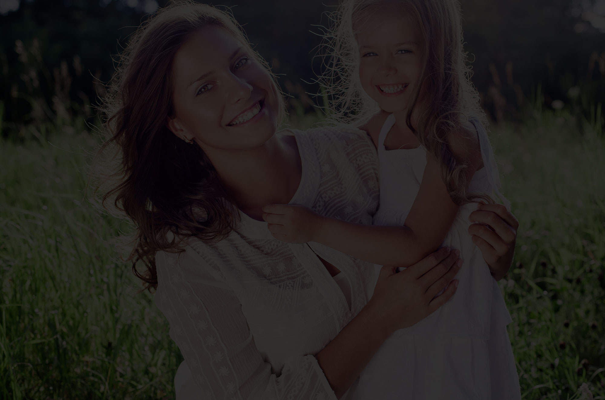 Beautiful mother posing with daughter in field.